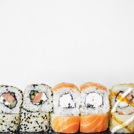 Closeup of traditional sushi roll with fish isolated on white background. Sushi bar menu design with copyspace.の写真素材