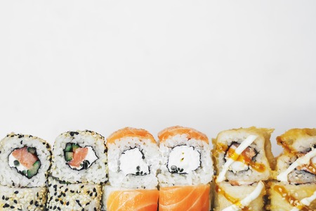 Closeup of traditional sushi roll with fish isolated on white background. Sushi bar menu design with copyspace.の写真素材
