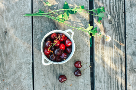 Fresh garden cherry in bowl on wooden table. Top view with copy spaceの写真素材