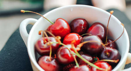 Sweet cherry close-up macro, lies on a plate. Antioxidant, natural, vitamin, organic berry. Drops of water on the surface of berries. Selective focus. Macro backgroundの写真素材