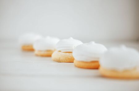 closeup white zephyr cookies lie to the line on white wooden backgroundの写真素材