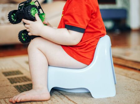 baby smiling and sitting on the pottyの写真素材
