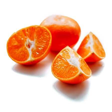 fresh mandarin fruit with cut and green leaves isolated on white backgroundの写真素材