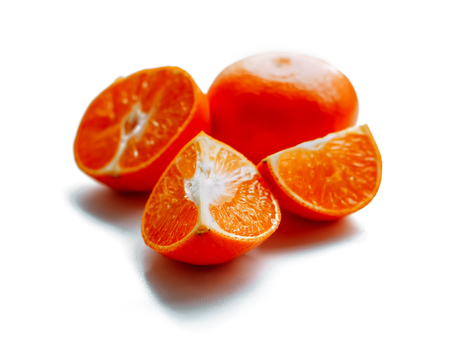 fresh mandarin fruit with cut and green leaves isolated on white backgroundの写真素材