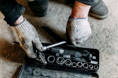 A top view image of hand tools. Set of tools on concrete panel background with copy space. Many chrome vanadium wrench tools and nuts on black box. DIY.の写真素材