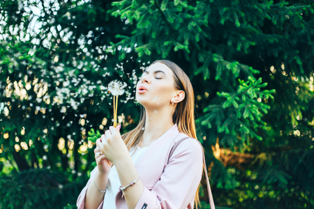 Pretty Girl Model Blowing Dandelion Laughing in a Summer timeの写真素材