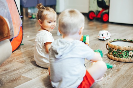 little boy and girl playing toys at homeの写真素材