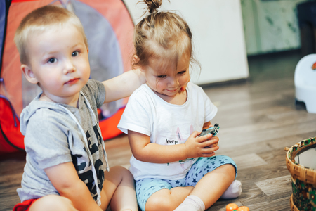 little girl and boy hug at homeの写真素材