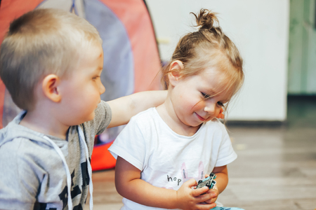 little girl and boy hug at homeの写真素材