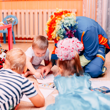 children paint drow paper on floor with clown celebrities birthday holidays play colored pencils eventの写真素材