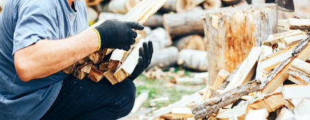 man hold firewood, he puts cutting wood into stack of wood woodpile long bannerの写真素材