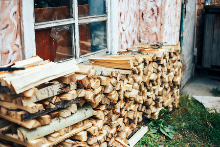 Firewood in woodpile under the sunshine Woodpiles background. Stacked firewood background, light brown firewood texture outdoors.の写真素材
