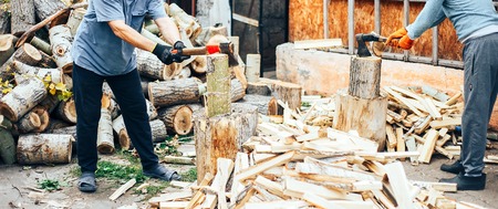 Detail of two flying pieces of wood on log with sawdust. Man is chopping wood with vintage axe. Frozen moment. long bannerの写真素材