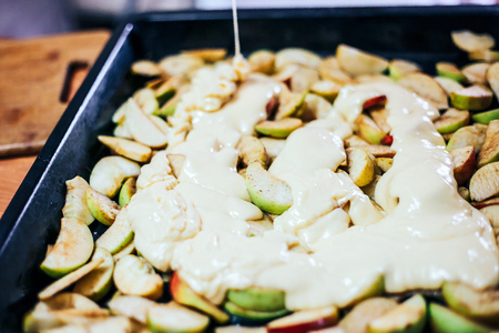 Close up of woman preparing apple pie on base pastry in the kitchenの写真素材