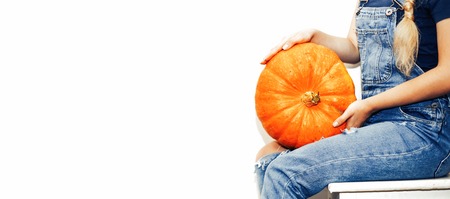 Funny teenage woman young schoolgirl holding halloween pumpkin and laughing isolated over white backgroundの写真素材