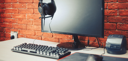 Computer display and gaming tools on desk. Desktop computer screen is black. Modern creative workspace background. Front view.の写真素材