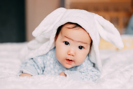 Closeup portrait of cute baby with black eyes in rabbit costumeの写真素材