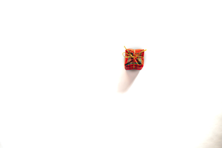 Gift box wrapped in red ang green paper with gold ribbon bow top view isolated on white background, clipping path includedの写真素材