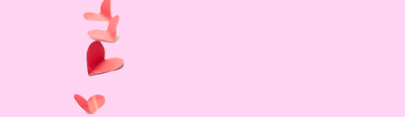 vertical line of Red paper hearts shape isolated on white selected focus soft focus minimalism valentines love concept long bannerの写真素材