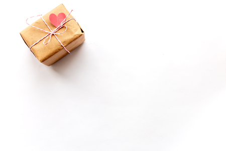 Wrapped vintage gift box with pink ribbon bow on white background with  paper heartの写真素材