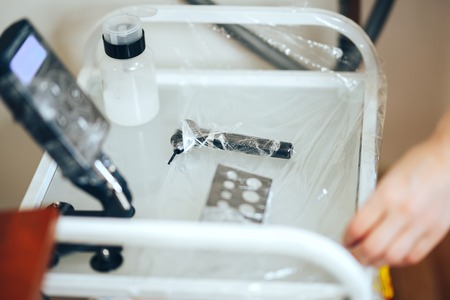 woman prepare instruments for permanent makeup to work use wrap tape for sterility, tools for tattoo ready to use.の写真素材