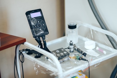 woman prepare instruments for permanent makeup to work use wrap tape for sterility, tools for tattoo ready to use.の写真素材