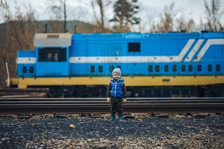 little boy posing for making photo with blue train.の写真素材