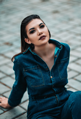 close up portrait of beautiful sexy young woman, in jeans costume and dark make up smoky eyesの写真素材