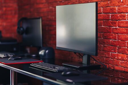 Two computer monitors with black screen on a desk, one workplace on table for two people.の写真素材