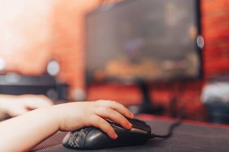 little boy playing games on computer in headphones with microphone, computer gameの写真素材