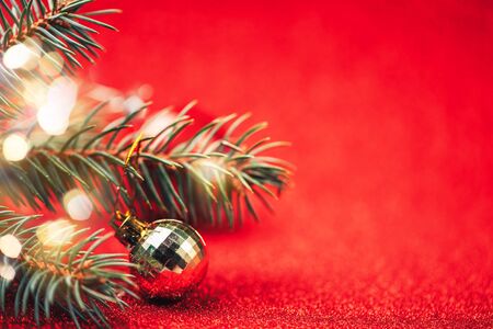 Close up of disco ball with spruce branches on red background, selected focus, blurred red background.の写真素材