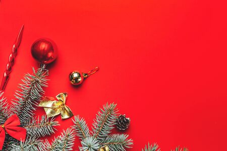 Christmas decorations with spruce branches, toys, red balls on red background, flat lay, space for text.の写真素材