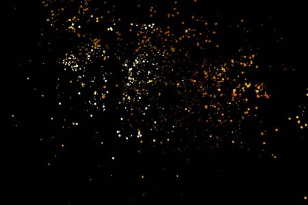 Golden sparkles on black backgroundの写真素材