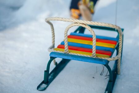 kid going up on a hill pulling color sledge.の写真素材