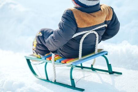 Boy on sleigh. Sledding at winter timeの写真素材