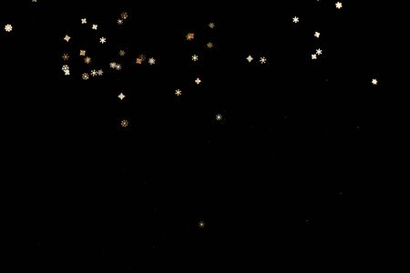 Golden glitter bokeh lights on black background, unfocused. Holiday time.の写真素材