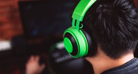 Back view of gamer in headphones playing video gameの写真素材