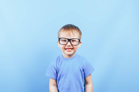 Angry small boy looking at camera in glassesの写真素材