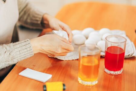 Preparing to Easter, Woman paint and color eggs with the help of napkins.の写真素材