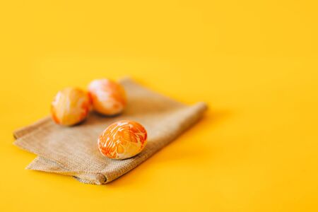 Three orange painted easter eggs, on green napkin.の写真素材