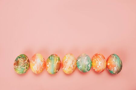 Top view of color easter eggs differen patterns. Line of eggs on yellow backgroundの写真素材