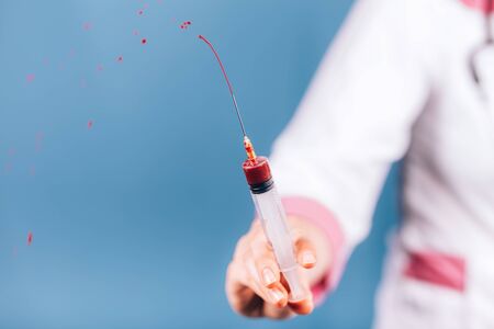 doctor with a syringe with bloodの写真素材