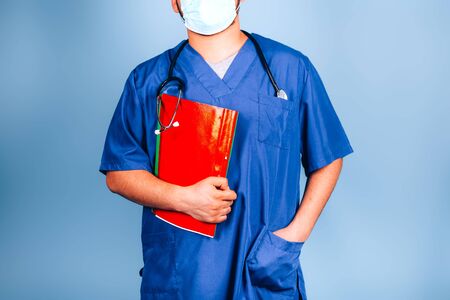 Young doctor with a red folder on a blue background in a blue uniform