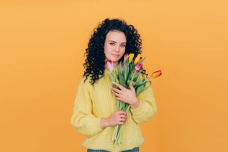 young beautiful girl holding bouquet of tulips