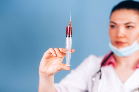 doctor with a syringe with bloodの写真素材