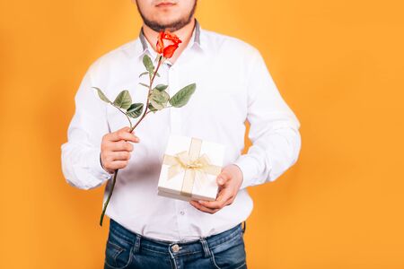 man holds a flower and a giftの写真素材