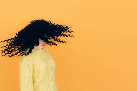 beautiful curly hair girl on yellow background