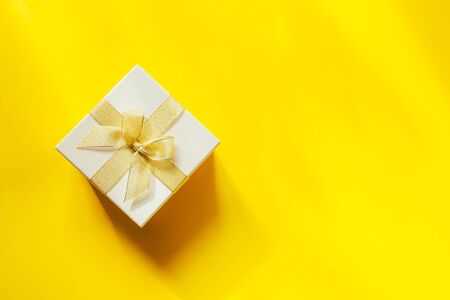 beautiful gift with ribbon on a bright yellow background, Mother's dayの写真素材
