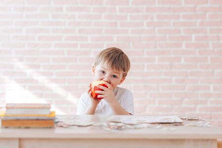 Beautiful little boy eats an appleの写真素材