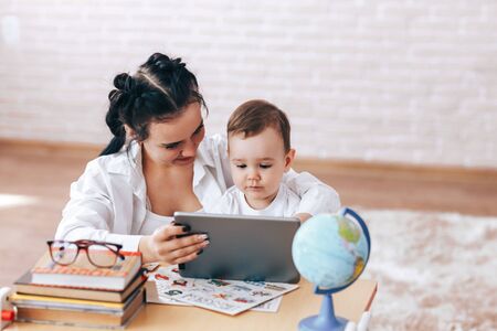Happy mom and son are watching a videoの写真素材